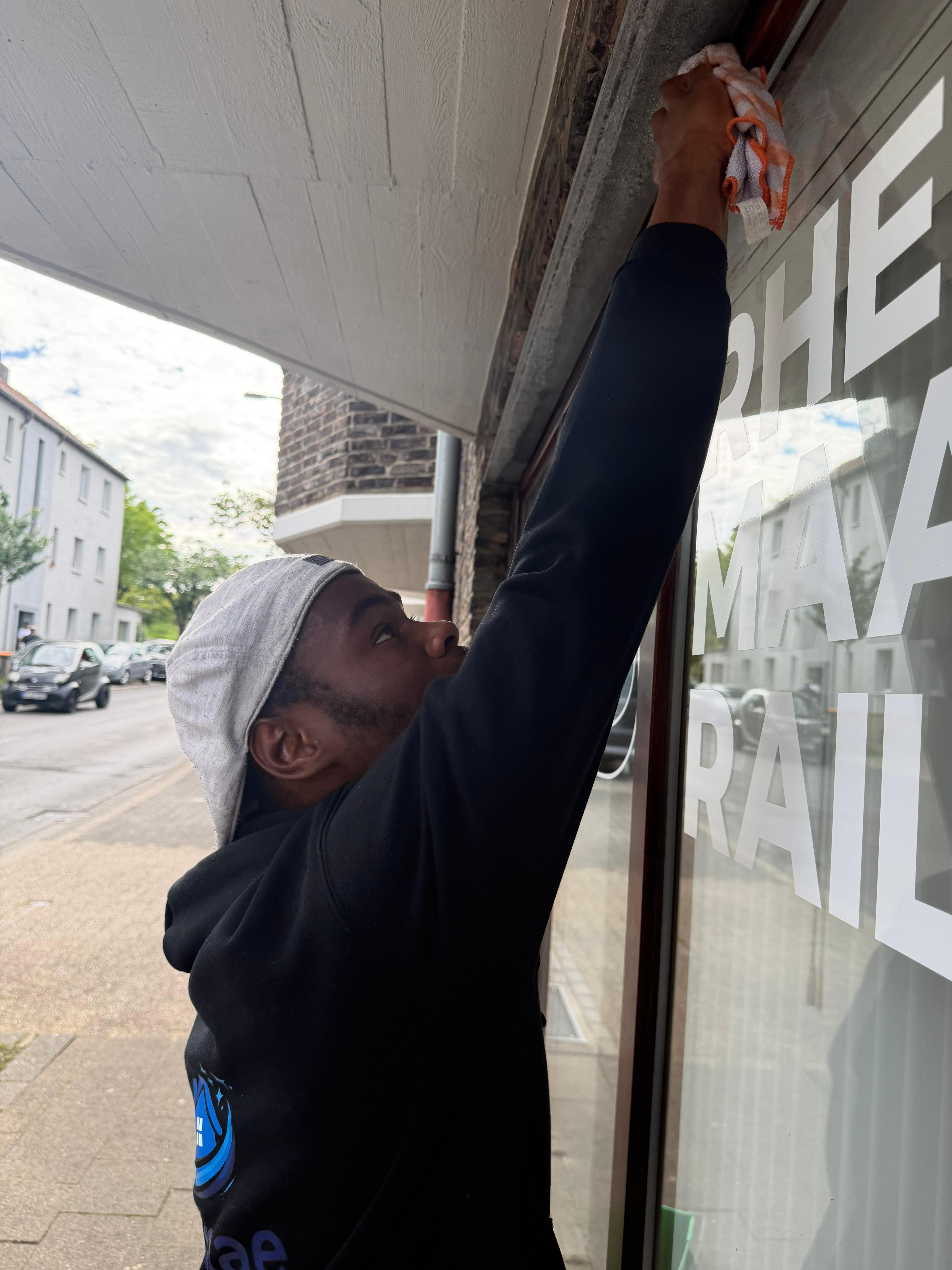 Nanae bei der Reinigung des oberen Fensterrahmens
